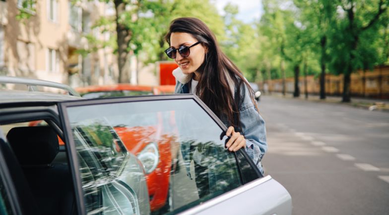 Young woman getting into a car share